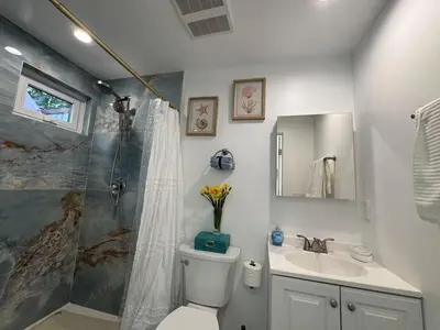 a bathroom with a shower and a toilet and a sink at Beach House by LA Coast in Torrance