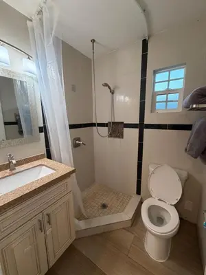 a bathroom with a toilet and a sink and a shower at Cozy 2-Bedroom Retreat Home in East Los Angeles in Hacienda Heights