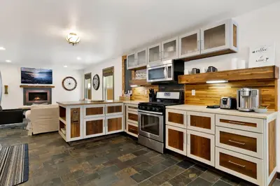 a kitchen with white cabinets and a stove top oven at Ursa Major Lodge | Walk to Lake & Village | Pet Friendly Retreat in Big Bear Lake