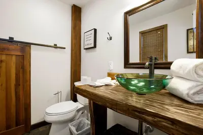a bathroom with a green bowl sink and a toilet at Ursa Major Lodge | Walk to Lake & Village | Pet Friendly Retreat in Big Bear Lake