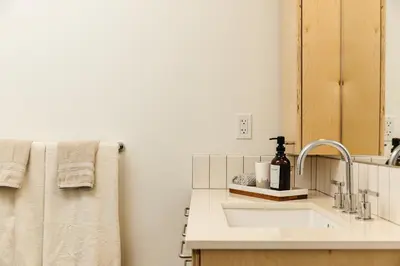 a bathroom with a sink and a mirror and towels at Fabulous and Spacious 2 level LOFT with Pool GyM Parking in Los Angeles