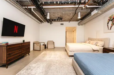a bedroom with two beds and a tv on the wall at Fabulous and Spacious 2 level LOFT with Pool GyM Parking in Los Angeles