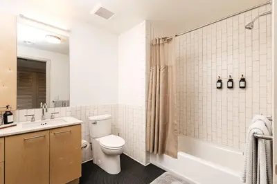 a bathroom with a toilet and a sink and a tub at Fabulous and Spacious 2 level LOFT with Pool GyM Parking in Los Angeles