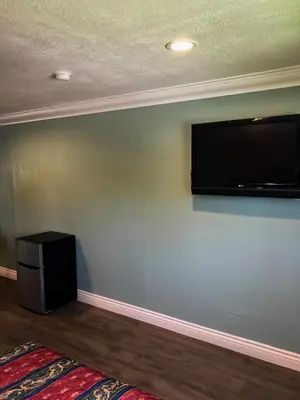 a room with a flat screen tv on a wall at Highland Park Motel in Los Angeles