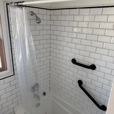 a white tiled bathroom with a shower and a tub at Cozy House in Hewitt
