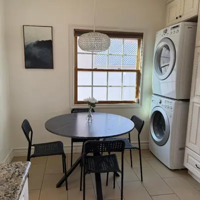 a kitchen with a table and a washer and dryer at Cozy House in Hewitt