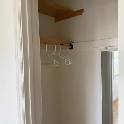 a closet with a rack on the wall next to a door at Cozy House in Hewitt