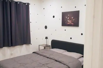 a bedroom with a bed and a wall with a picture at The Warmwood Retreat in Los Angeles