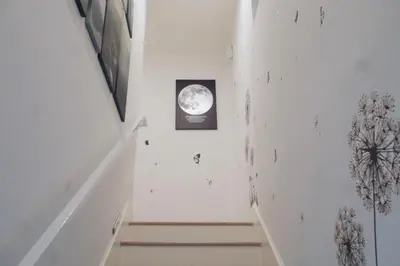 a white staircase with a picture of the moon on the wall at The Warmwood Retreat in Los Angeles