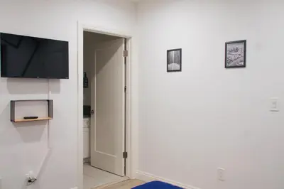 a hallway with a door and a tv on a wall at The Warmwood Retreat in Los Angeles