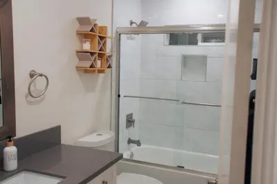 a bathroom with a toilet and a glass shower at The Warmwood Retreat in Los Angeles