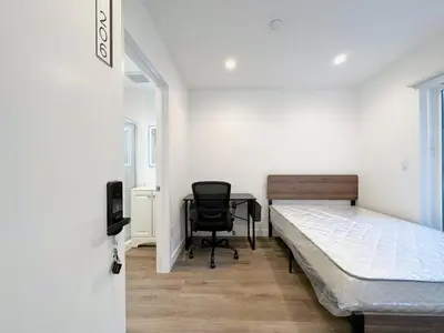 a bedroom with a bed and a desk and a chair at Eiven Homestay in Los Angeles