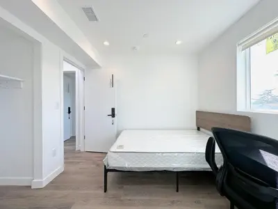 a bedroom with a bed and a chair in it at Eiven Homestay in Los Angeles
