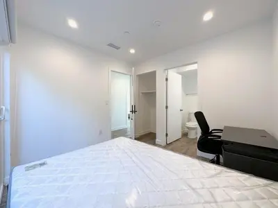 a white bedroom with a bed and a desk at Eiven Homestay in Los Angeles