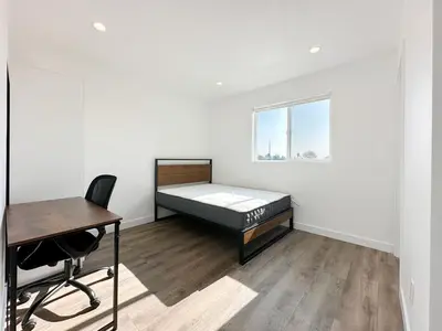 a bedroom with a bed and a desk and a chair at The 1443 in Los Angeles