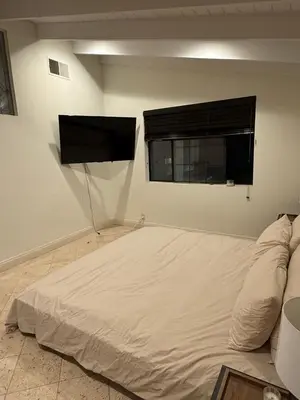 a white room with a bed and a window at Venice beach in Los Angeles
