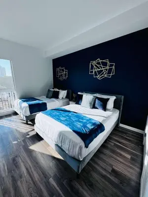 two beds in a bedroom with blue walls at The Central Apartment at Hollywood in Los Angeles