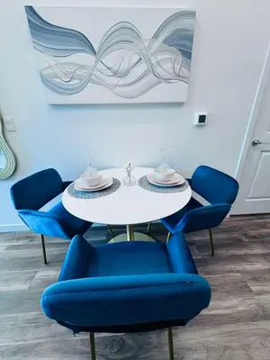 a white table with blue chairs in a room at The Central Apartment at Hollywood in Los Angeles