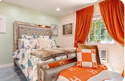 a bedroom with a bed with orange curtains at Zen guess house in Los Angeles