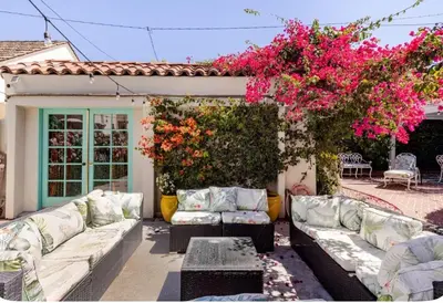 a patio with white couches and pink flowers at Zen guess house in Los Angeles
