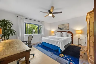 a bedroom with a bed with a ceiling fan and a table at Private Estate with Cottage, Pool & Tennis in Ojai