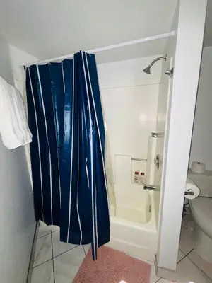 a bathroom with a blue shower curtain and a toilet at 1Bd Prime Westwood Location One Block from UCLA in Los Angeles