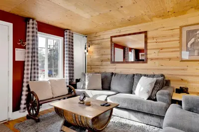 a living room with a couch and a table at Highland Hideaway at Big Bear | Cozy Cabin w/ Private Hot Tub in Big Bear Lake