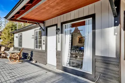a building with a large sliding glass door on a patio at Highland Hideaway at Big Bear | Cozy Cabin w/ Private Hot Tub in Big Bear Lake