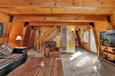 a living room with a couch and a table at The Cave at Big Bear Lake - Adorable Mountain Retreat w/ Hot Tub in Big Bear Lake