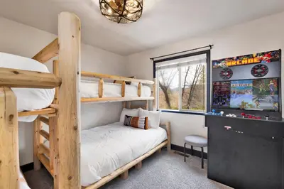a bedroom with two bunk beds and a television at Cielos Nest Cabin | Close to Village and Lake with Hot Tub in Big Bear Lake