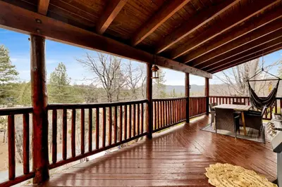 a screened in porch with a hammock and a table on it at Cielos Nest Cabin | Close to Village and Lake with Hot Tub in Big Bear Lake