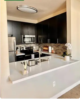 a kitchen with black cabinets and a white counter top at Spacious 1B 1B Pool View Loft Apartment in Marina Del Rey in Los Angeles