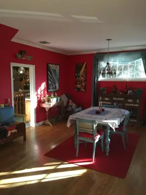 a living room with a table and red walls at Elaine's Hollywood Bed & Breakfast in Los Angeles