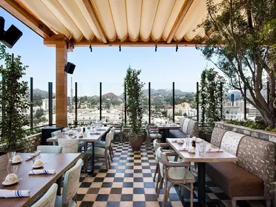 a restaurant with tables and chairs and a checkered floor at Dream Hollywood, by Hyatt in Los Angeles