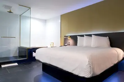 a bedroom with a large bed and a glass shower at Glen Capri Inn and Suites - Burbank Universal in Glendale