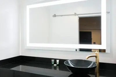 a bathroom with a black sink and a mirror at Glen Capri Inn and Suites - Burbank Universal in Glendale
