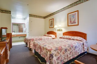 a hotel room with two beds and a bathroom at Vagabond Inn Hacienda Heights in Hacienda Heights