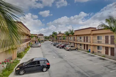 a parking lot with cars parked in front of buildings at Vagabond Inn Hacienda Heights in Hacienda Heights