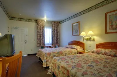 a hotel room with two beds and a television at Vagabond Inn Hacienda Heights in Hacienda Heights