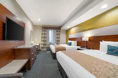 a hotel room with two beds and a flat screen tv at Best Western Plus Gardena-Los Angeles Inn & Suites in Gardena