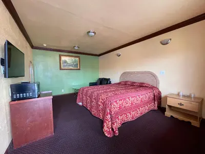 a hotel room with a bed and a tv at Welcome Inn in Inglewood