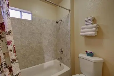 a bathroom with a shower and a tub and a toilet at Welcome Inn in Inglewood