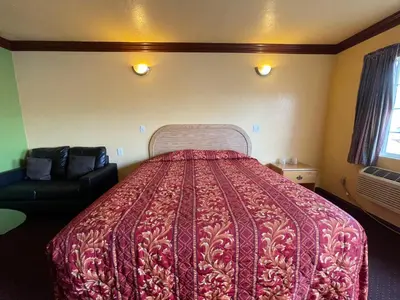 a bedroom with a bed with a red bedspread at Welcome Inn in Inglewood