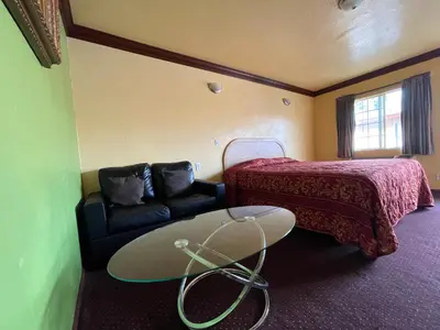 a hotel room with a bed and a table and a couch at Welcome Inn in Inglewood