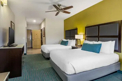 a hotel room with two beds and a flat screen tv at Best Western Plus Taft Inn in Taft