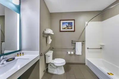 a bathroom with a toilet and a sink and a tub at Best Western Plus Taft Inn in Taft