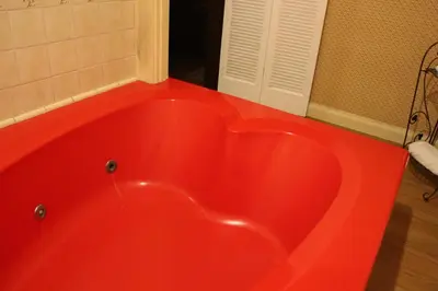a red bath tub in a bathroom with a door at Glen Tavern Inn in Santa Paula