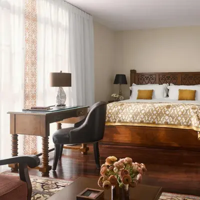 a bedroom with a bed and a desk with a desk at Plaza la Reina in Los Angeles