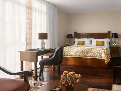a bedroom with a bed and a desk with a desk at Plaza la Reina in Los Angeles