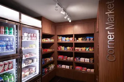 a kitchen with a refrigerator and shelves of food at Fairfield Inn & Suites By Marriott Camarillo in Camarillo